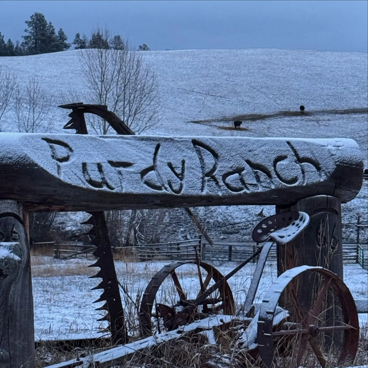 The Purdy Ranch sign in winter, with a vintage wagon wheel