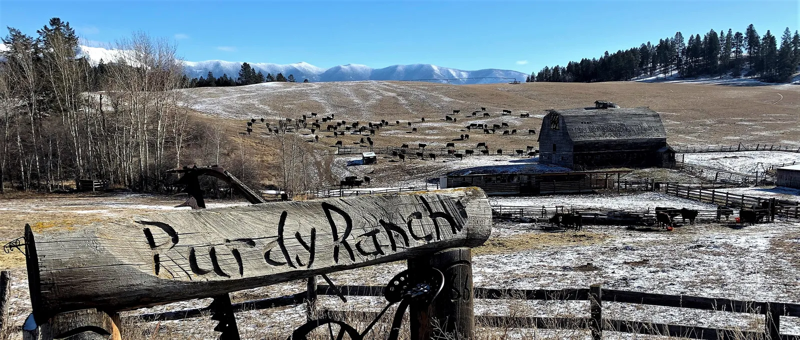The Purdy Ranch sign in winter, with a vintage wagon wheel